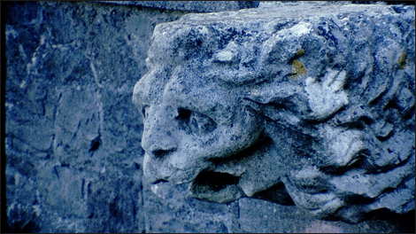 16mm frame showing a lion's head carved in stone